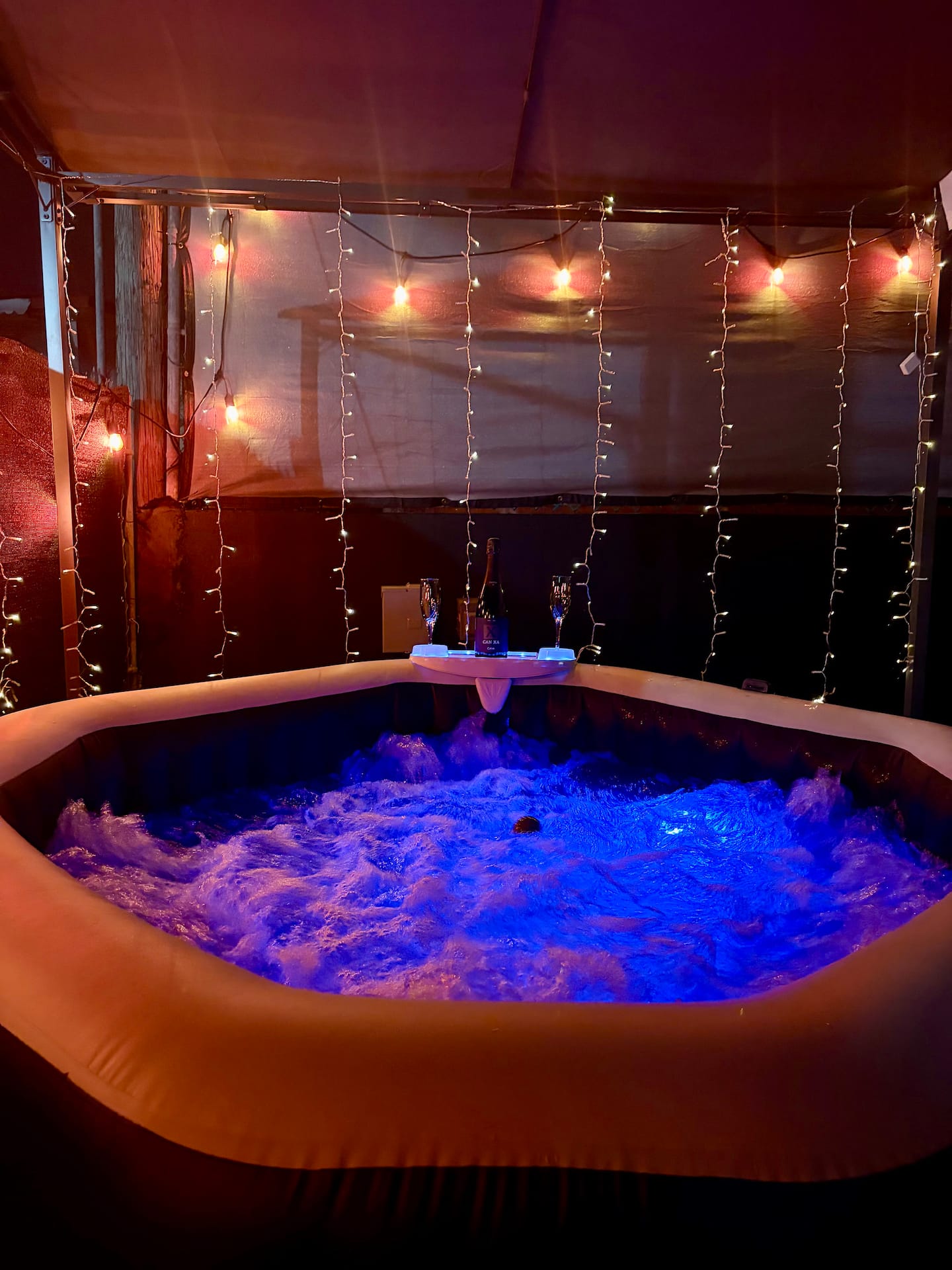 Jacuzzi privado iluminado de noche en el patio del camper
